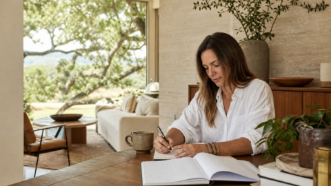 Calm founder workspace with notebook, coffee, plants, garden view, and soft morning light.