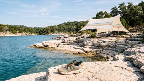 A Neso Grande sun shelter and Danner water shoes on the uneven limestone shoreline of Lake Travis.