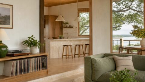 Lakehouse living room and kitchen with plants, records, books, open windows, warm natural light, and clean organic materials.